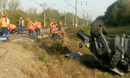 Перевернутый комбайн после столкновения с поездом 